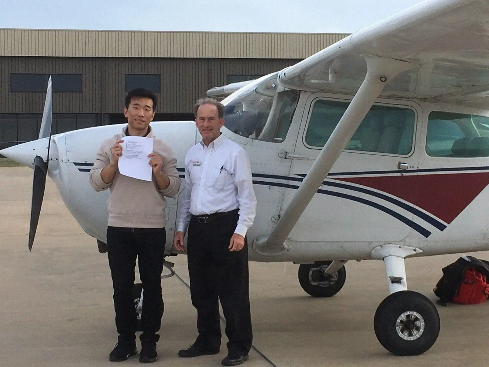 Student receiving a pilot certificate from an Alto Flight Academy instructor